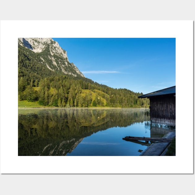 Lake water reflections with wooden boathouse wide angle. Amazing shot of a wooden house in the Ferchensee lake in Bavaria, Germany, in front of a mountain belonging to the Alps. Wall Art by EviRadauscher